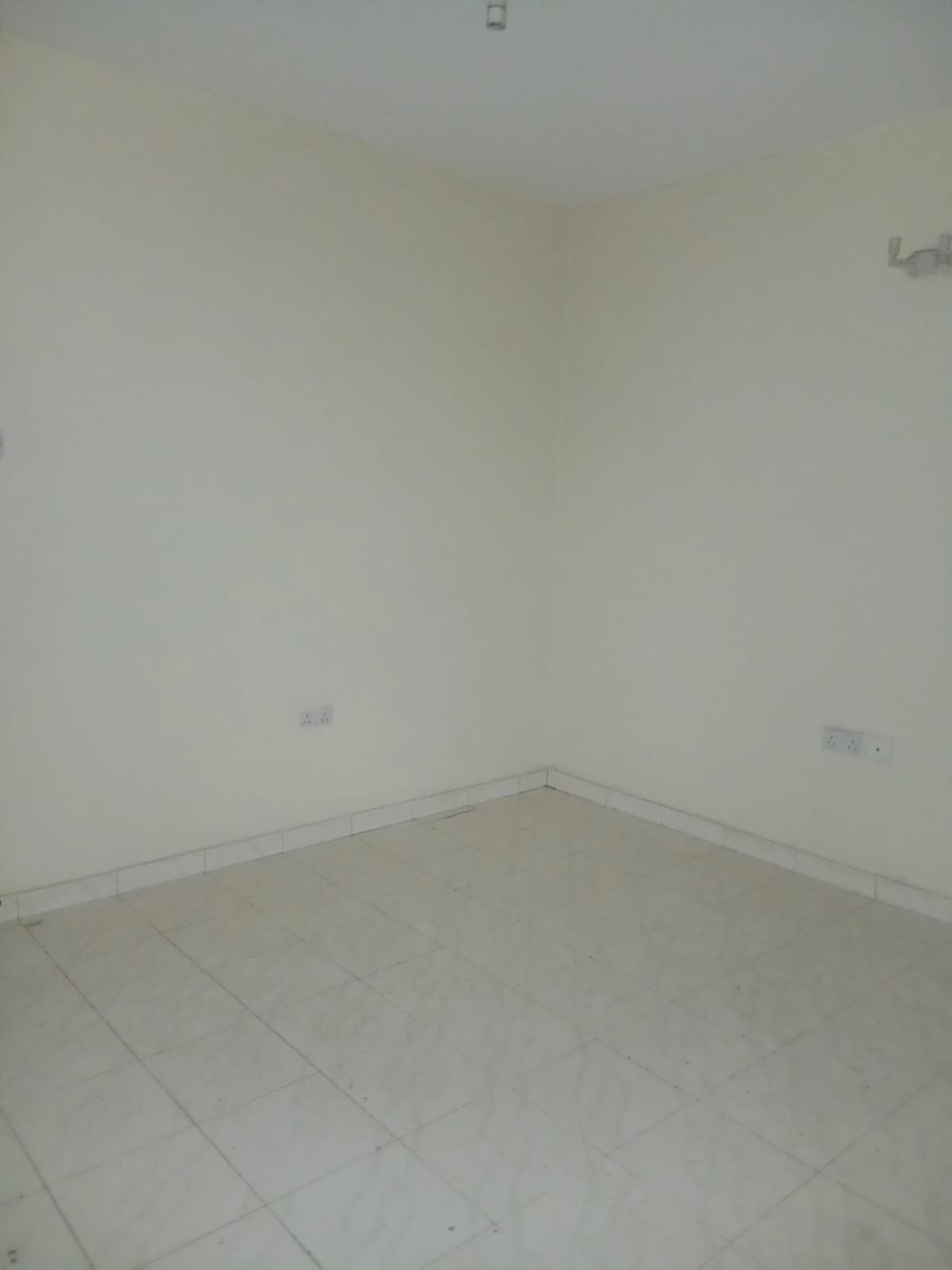 Empty bedroom with plain walls and tiled flooring