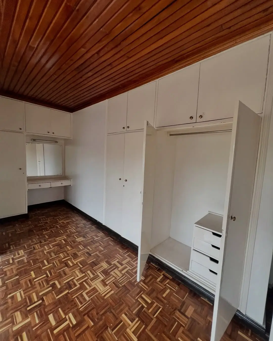 Spacious bedroom with built-in wardrobes and wooden ceiling