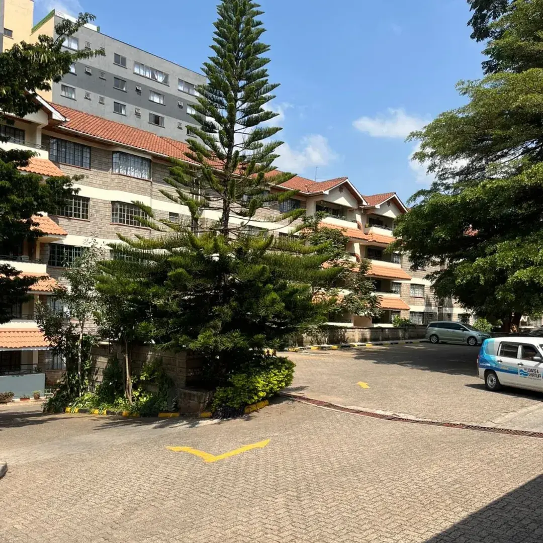 Multi-story residential compound with paved parking area