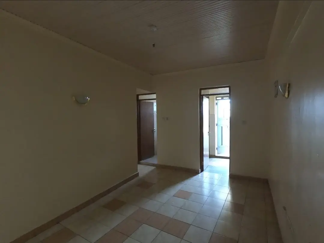 Empty corridor with tiled floor and multiple doorways