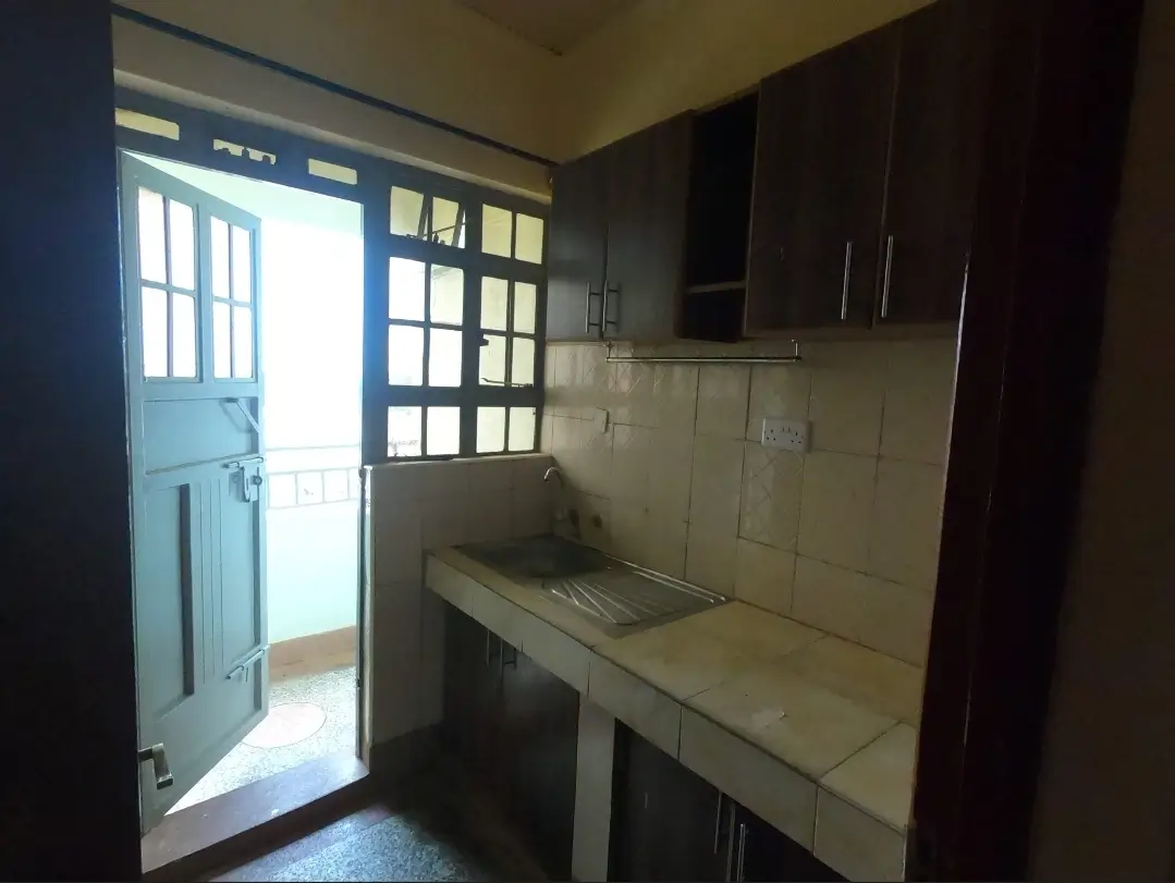 Compact kitchen with dark cabinets and stainless steel sink