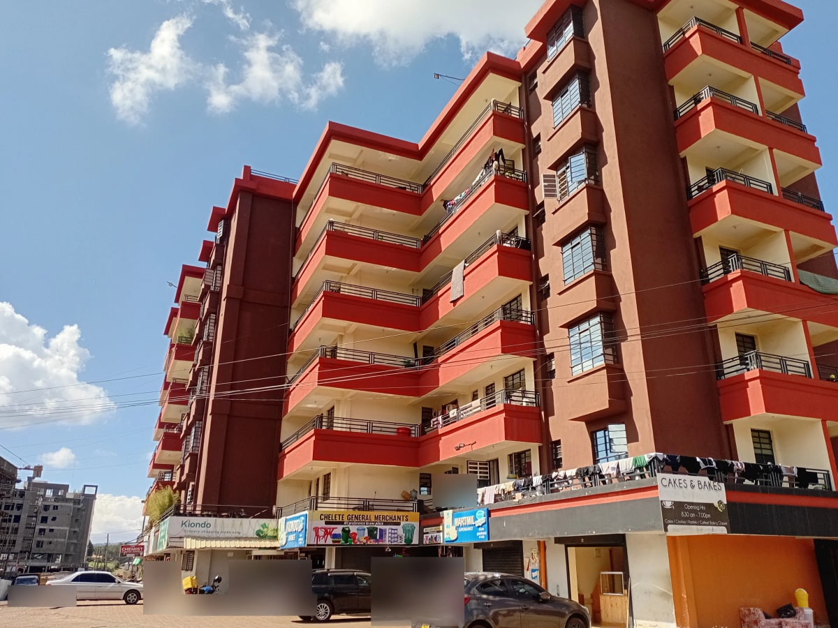 Multi-story residential building with red facade and balconies