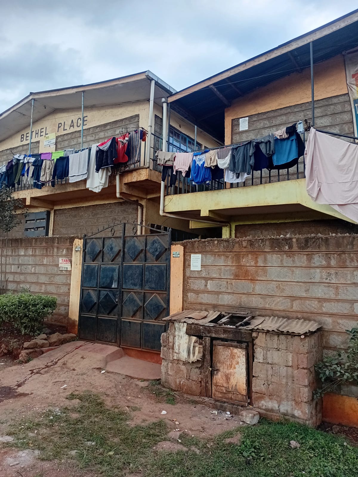 Multi-story residential building facade with clotheslines and gate