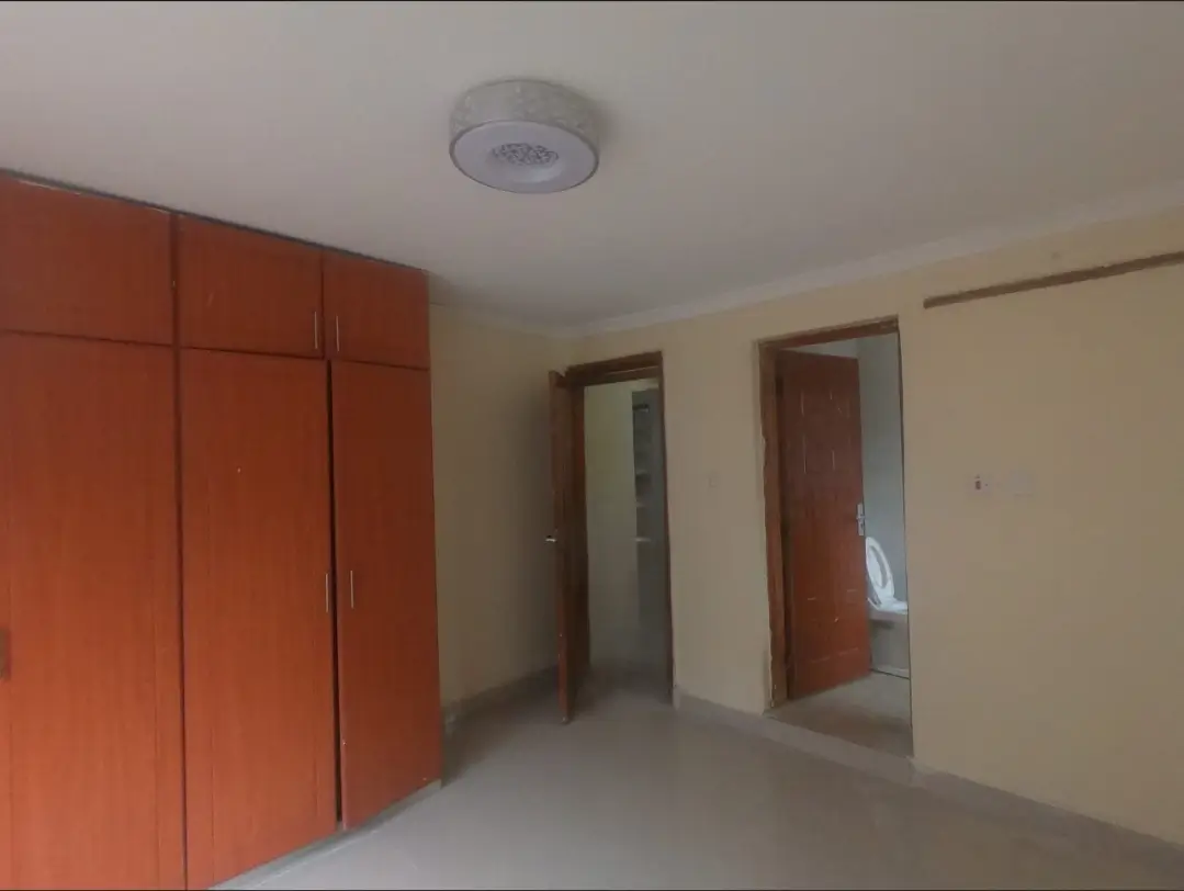 Spacious bedroom with built-in red wardrobes and multiple doors