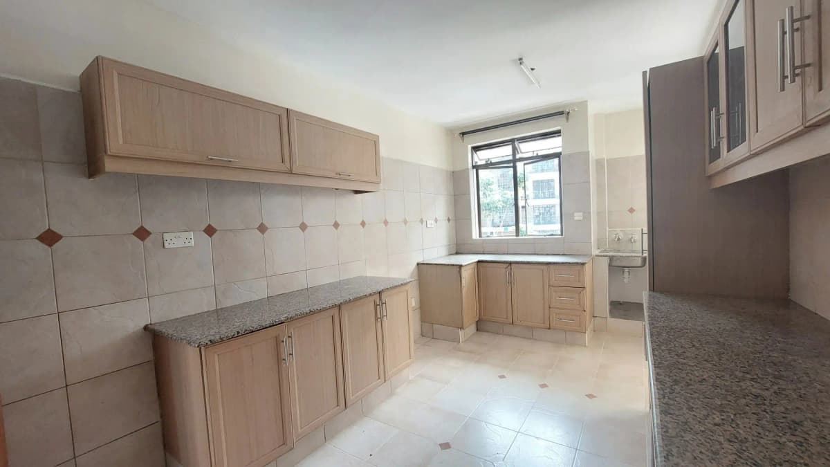 Spacious kitchen with wooden cabinetry and granite countertop