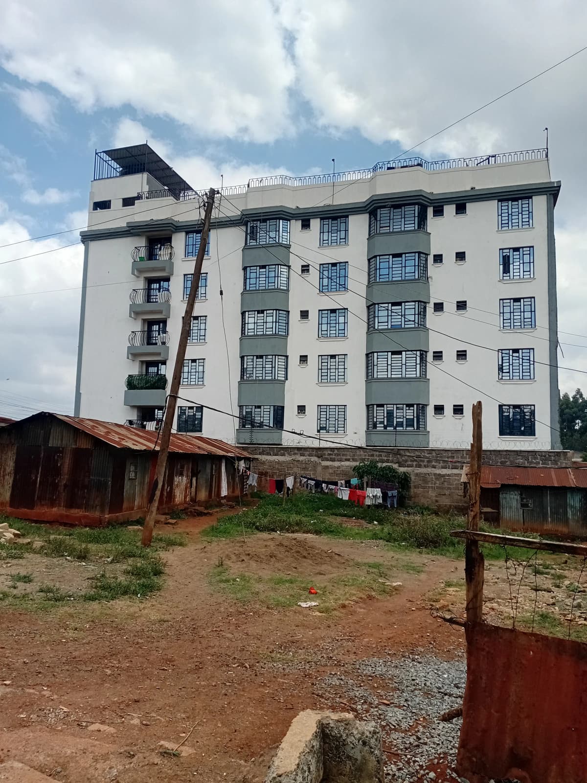 Multi-story residential building facade with compound grounds