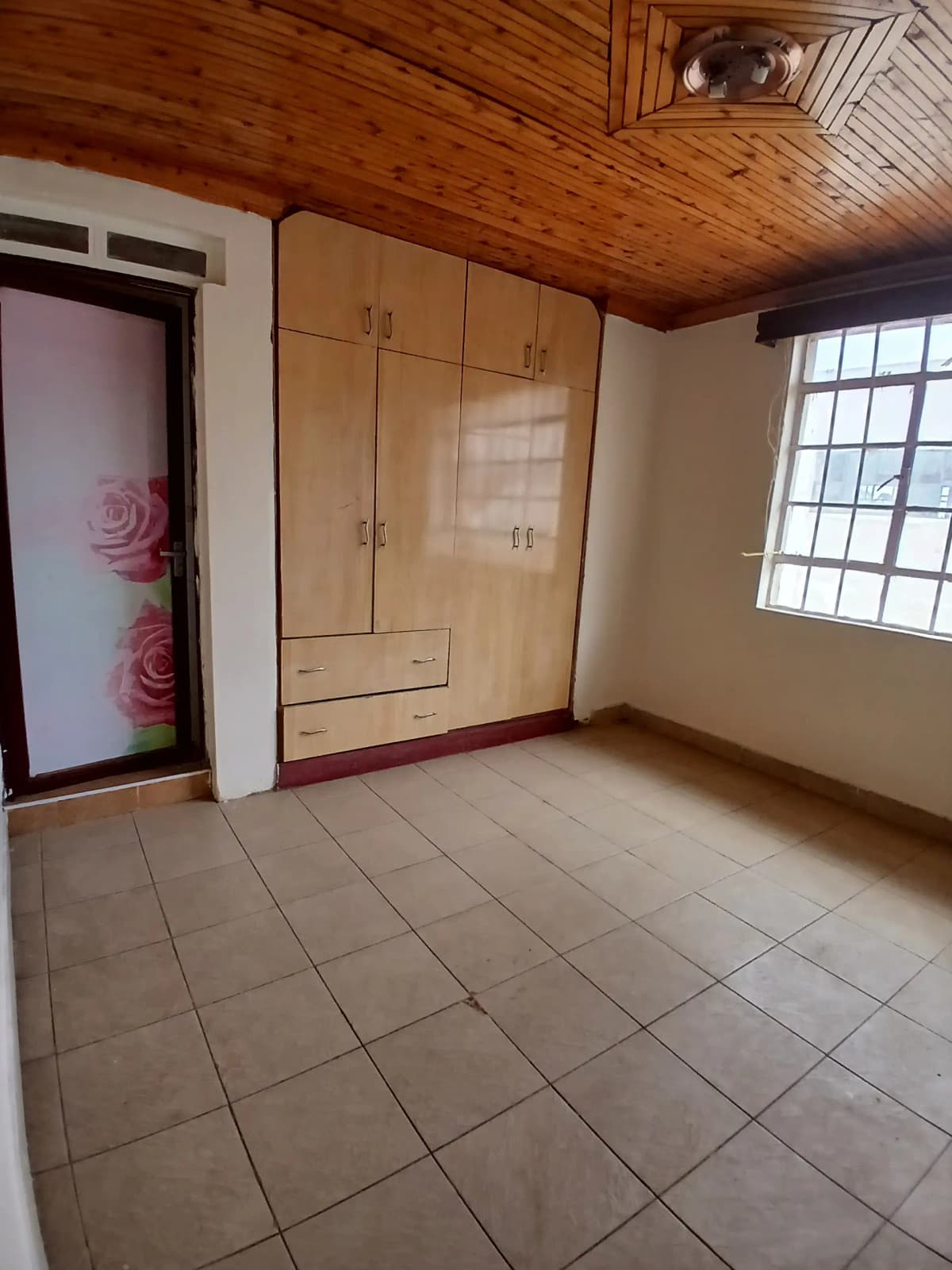 Bedroom with wooden ceiling, built-in wardrobe, tiled floor