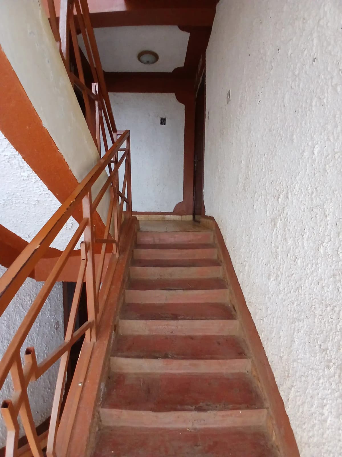 Interior stairwell with wooden steps and metal railing