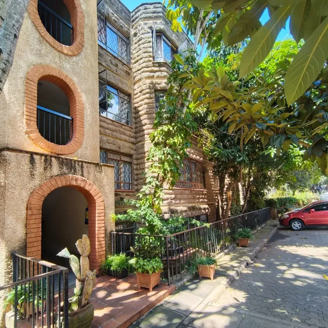 Historic brick building facade with arched entrance and ivy