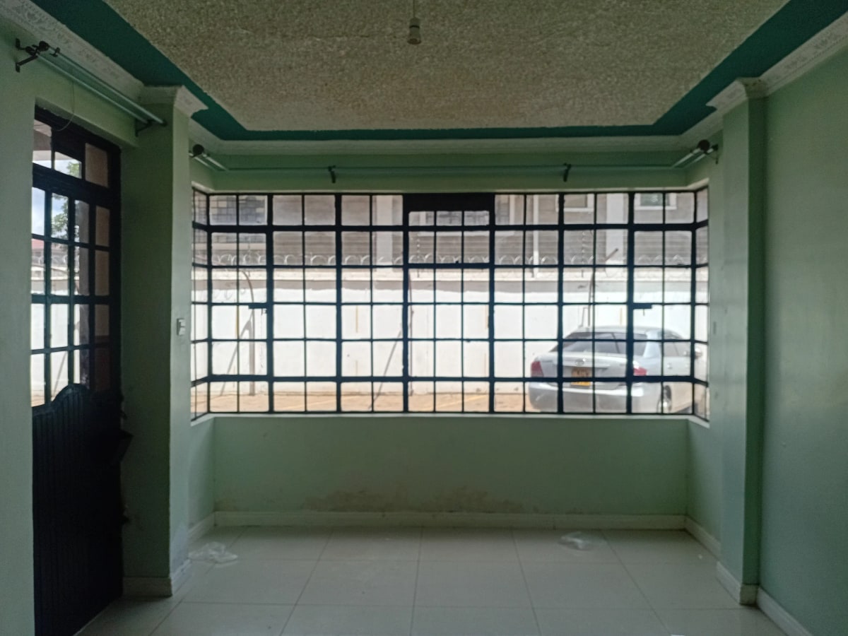 Empty living room with barred windows and green painted walls