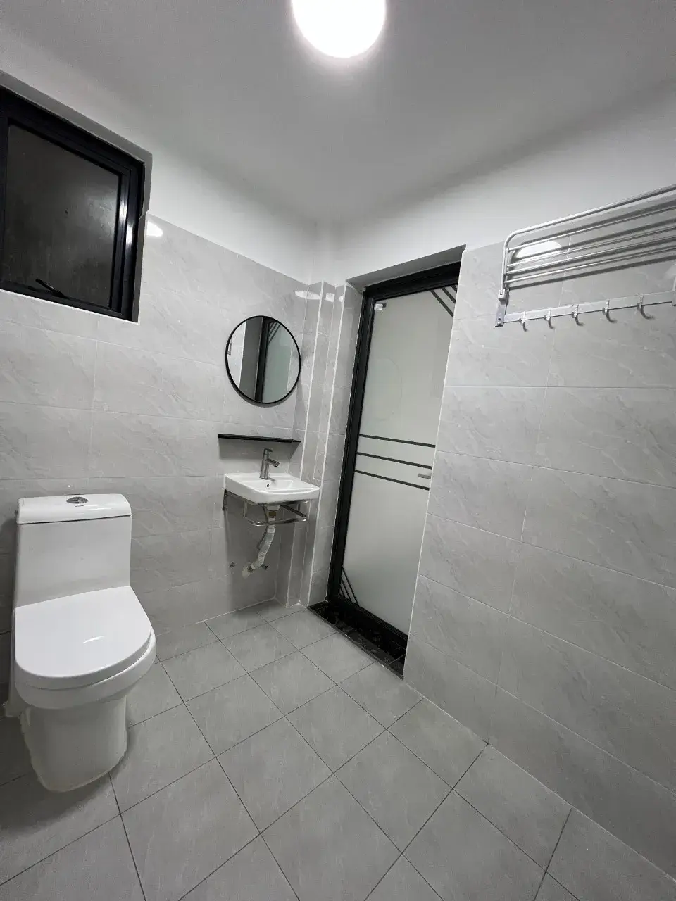 Clean bathroom with toilet, sink, mirror, and towel rack