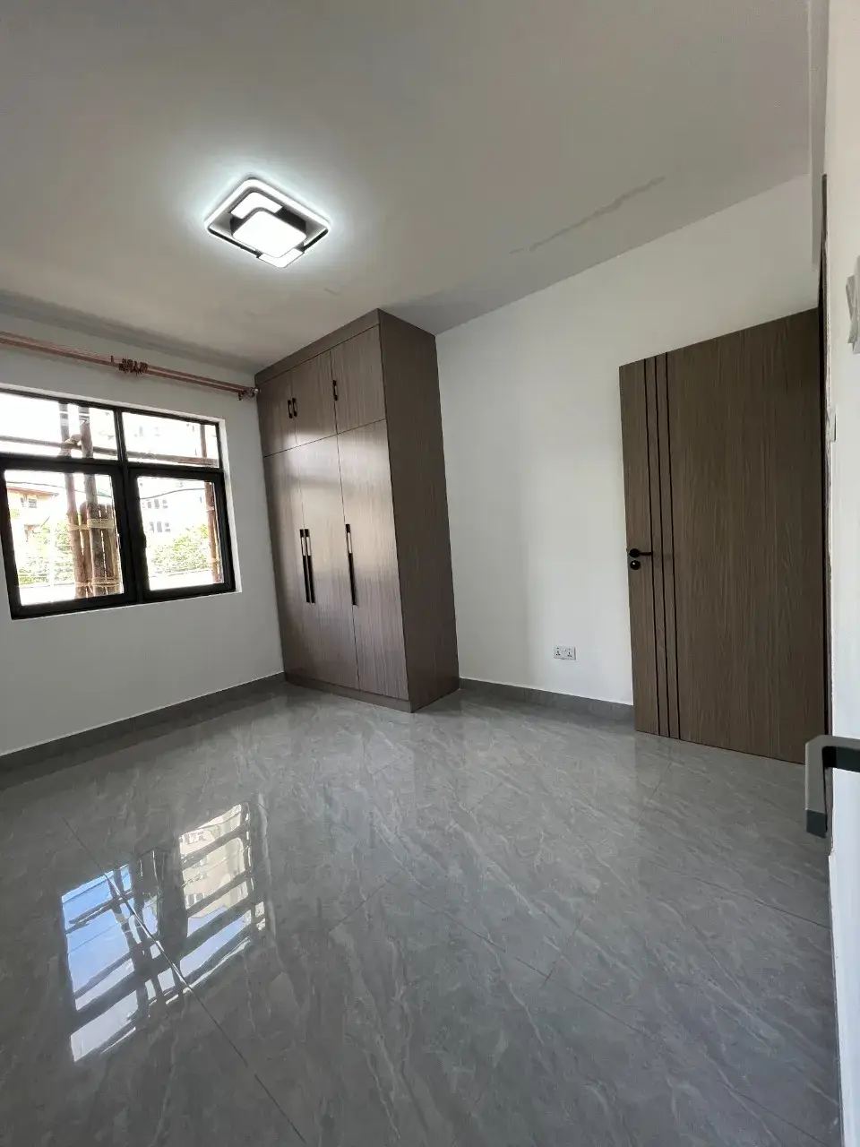 Spacious bedroom with built-in wardrobe and polished concrete floor
