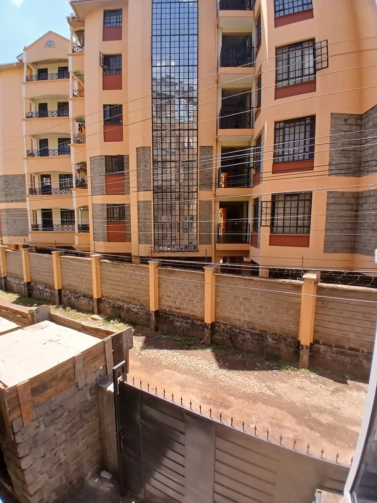 Multi-story residential building facade with perimeter fence