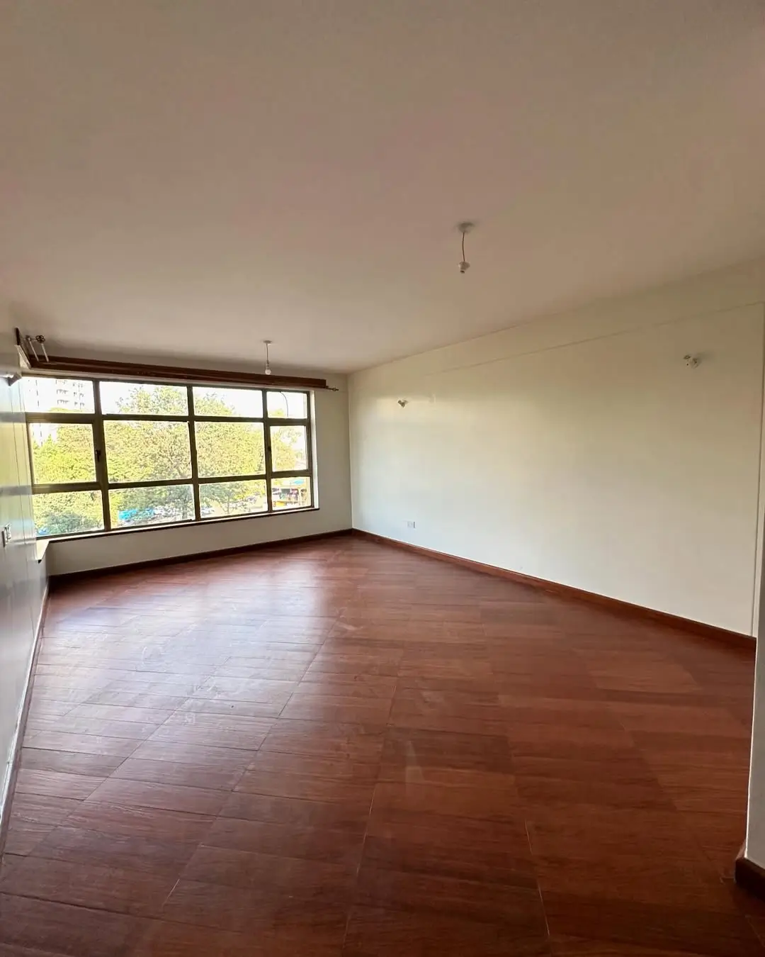 Spacious living room with wooden floors and large windows