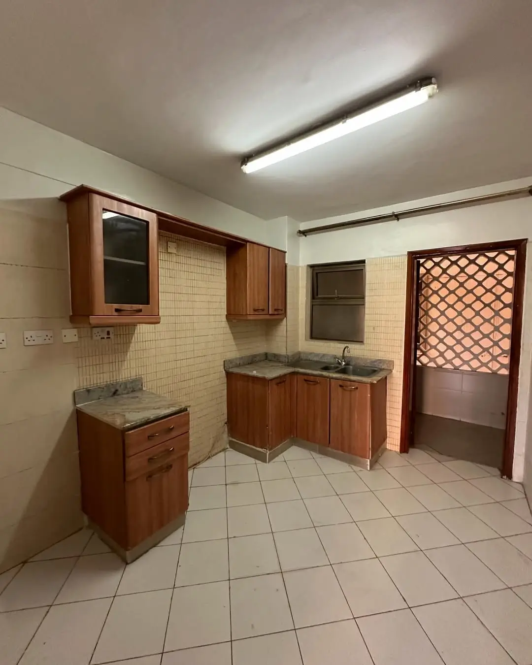 Spacious kitchen with wooden cabinets and tiled flooring