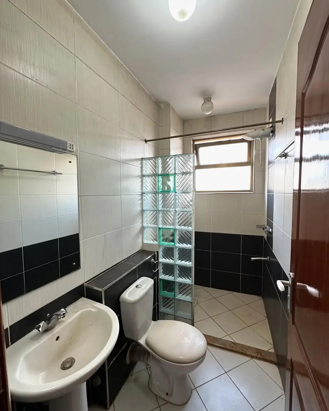 Modern bathroom with black tile accents and glass shower enclosure