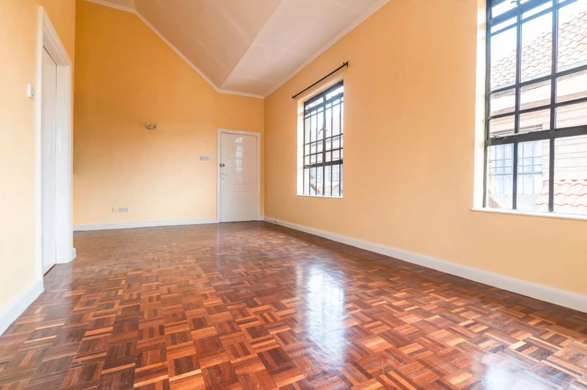 Spacious living room with herringbone wood flooring and bright windows