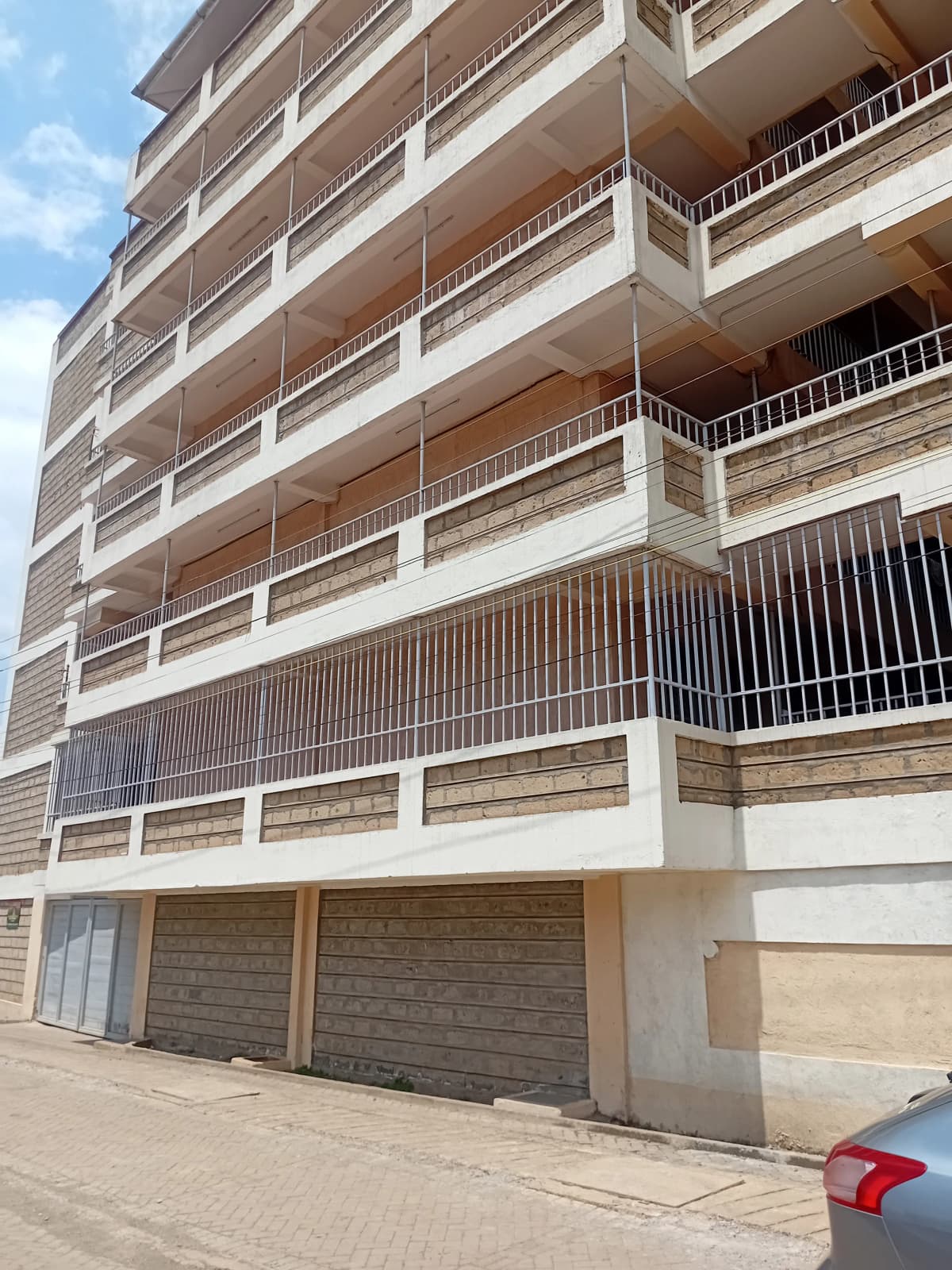 Ground-level parking garage with multiple residential floors above