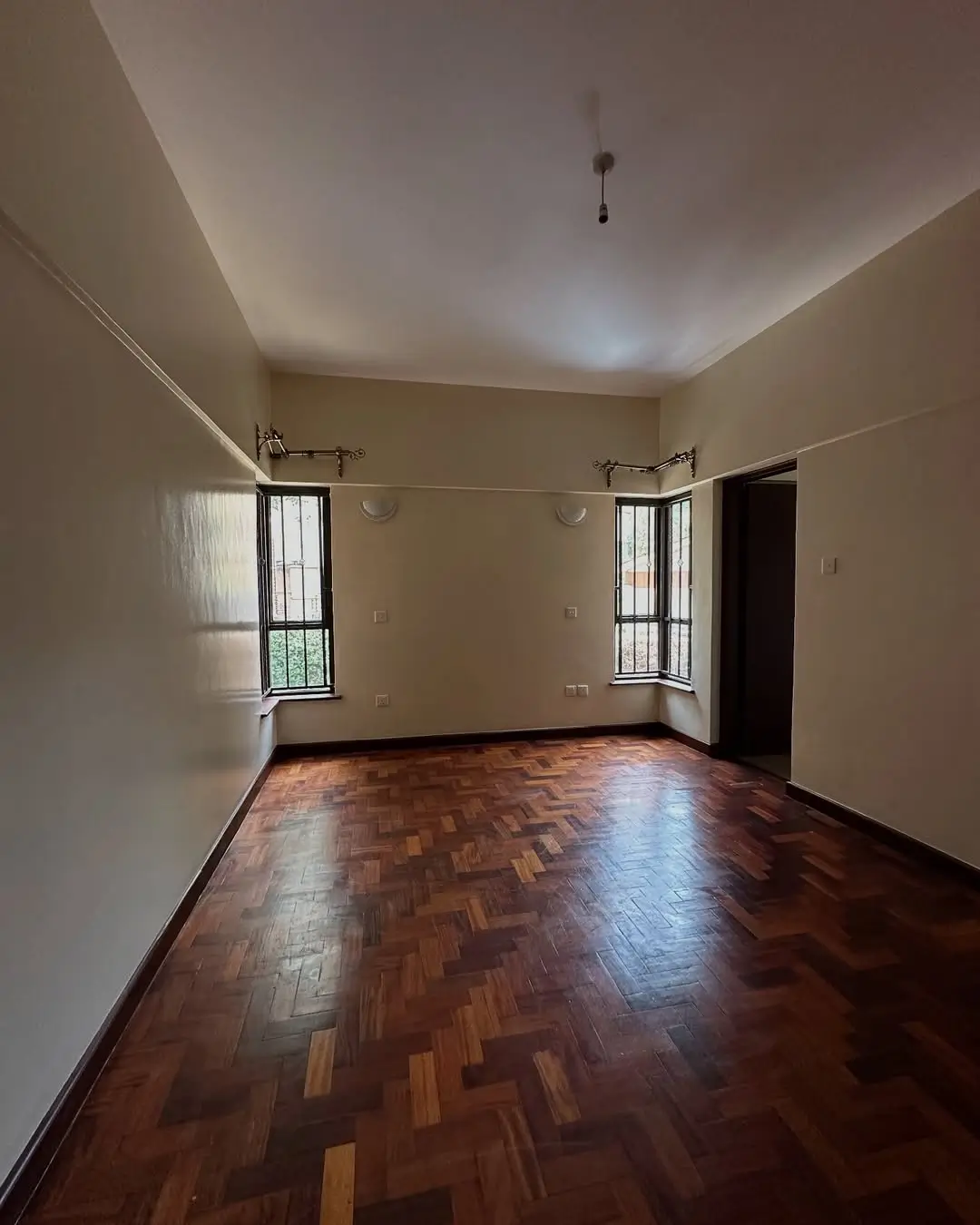 Spacious living room with wooden parquet floors and natural light