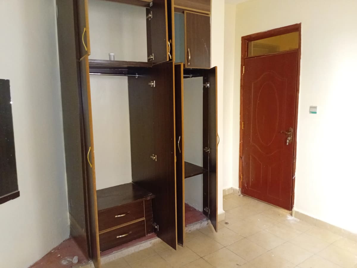 Bedroom with dark wooden built-in wardrobe and red door