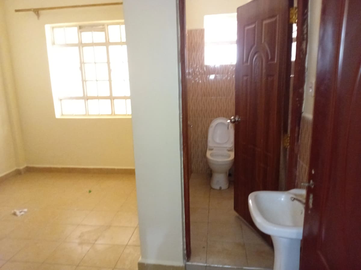 Basic bathroom with toilet and pedestal sink, tiled floor