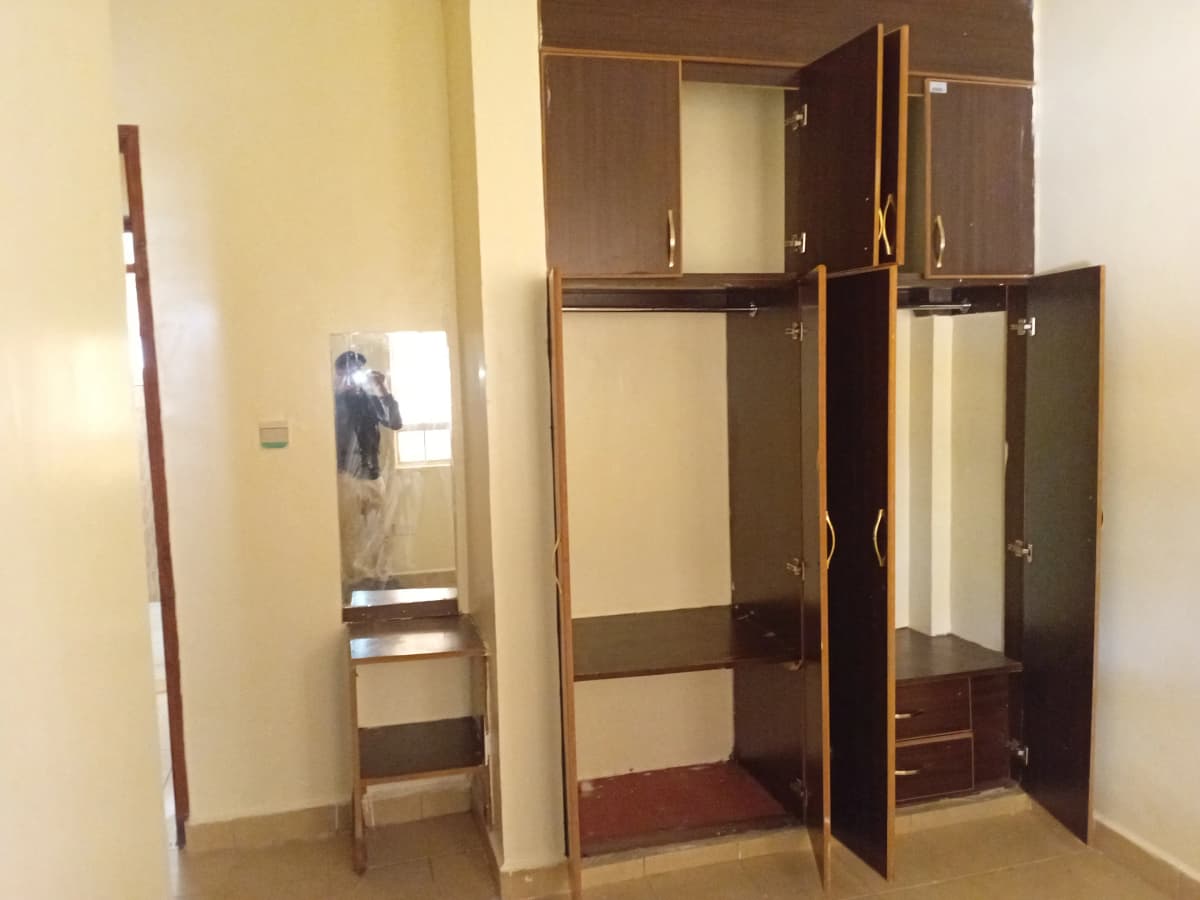 Bedroom with built-in wooden wardrobe and mirror