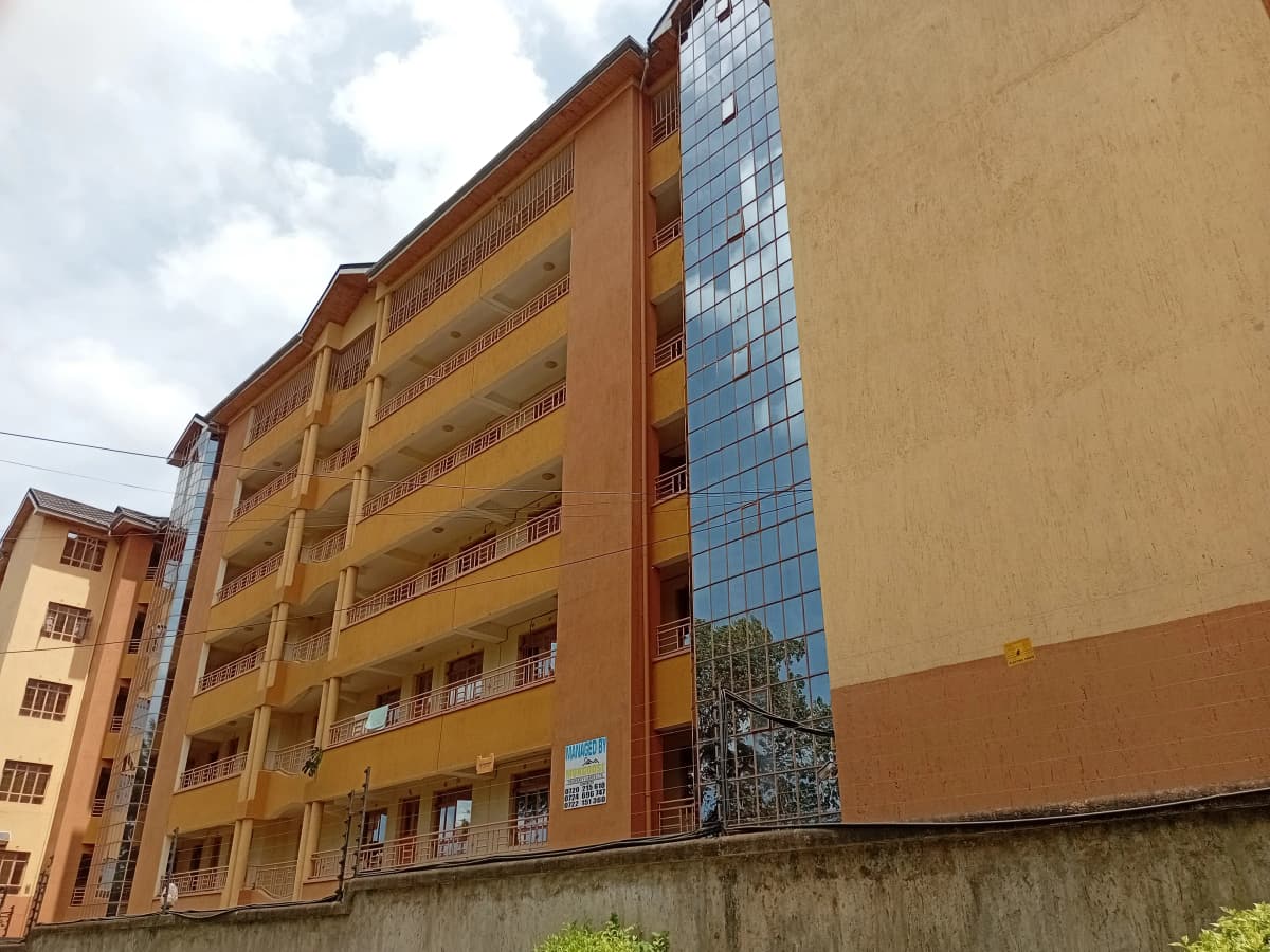 Multi-story residential building with ochre facade and balconies