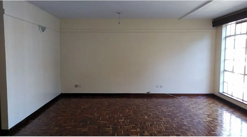 Spacious empty living room with herringbone wood flooring