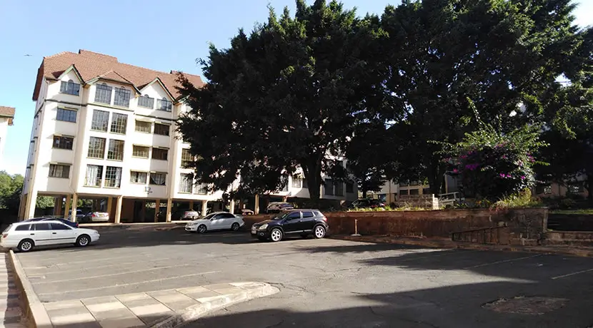 Multi-story residential building with ground-level parking compound