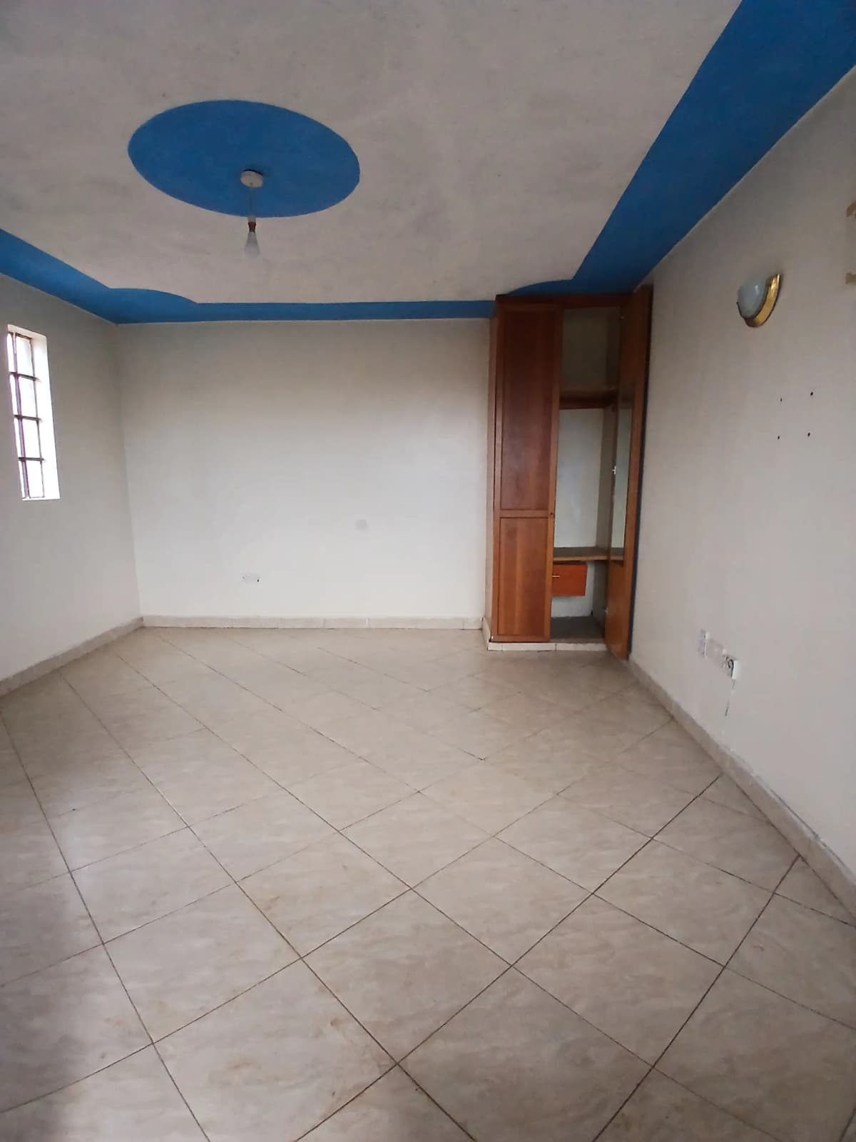 Empty living space with blue ceiling trim and tile flooring