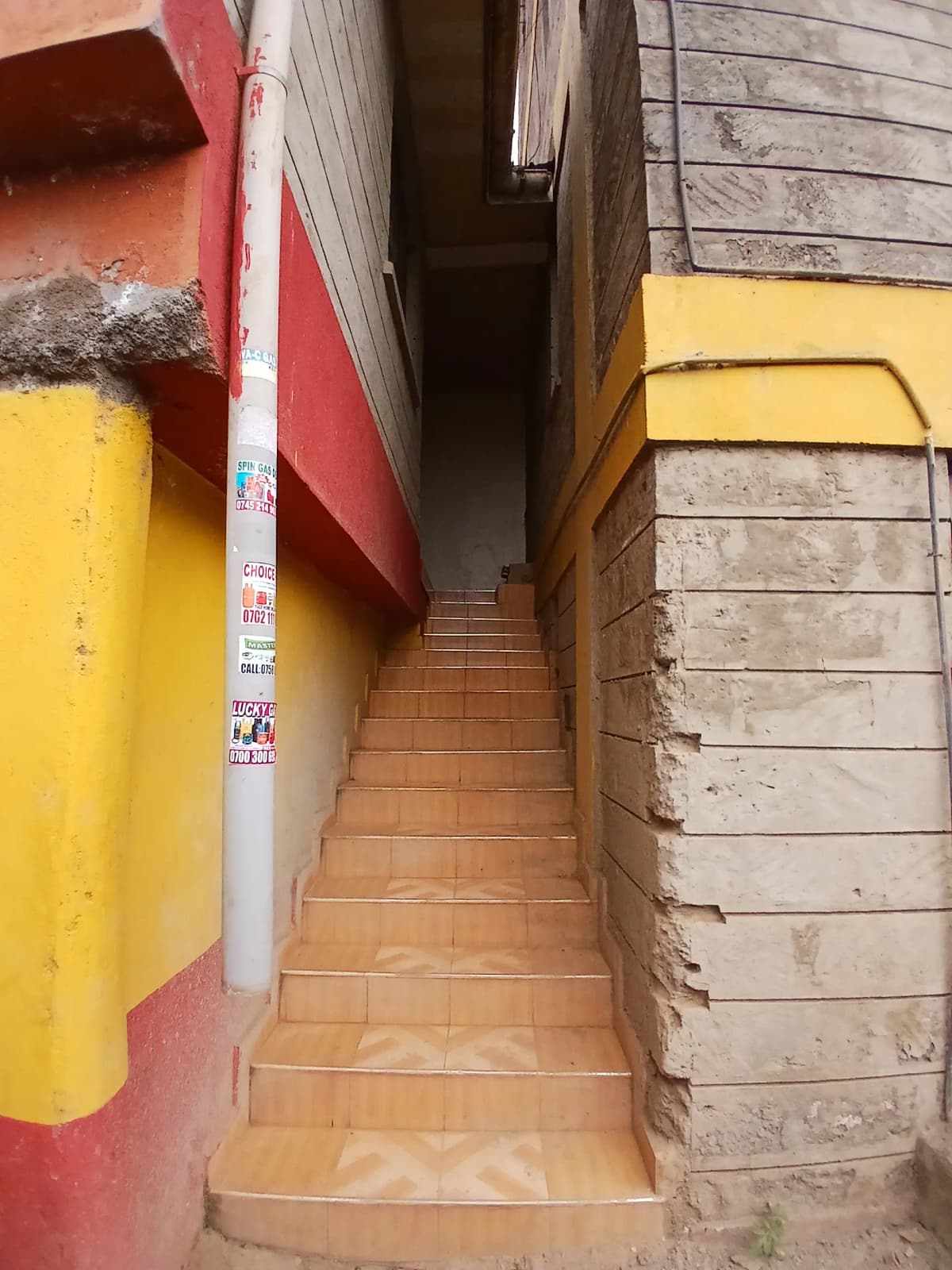 Narrow terracotta-tiled corridor with colorful painted walls