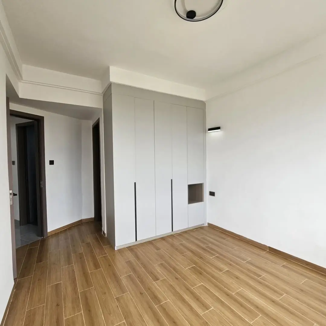 Modern bedroom with built-in wardrobes and wooden flooring