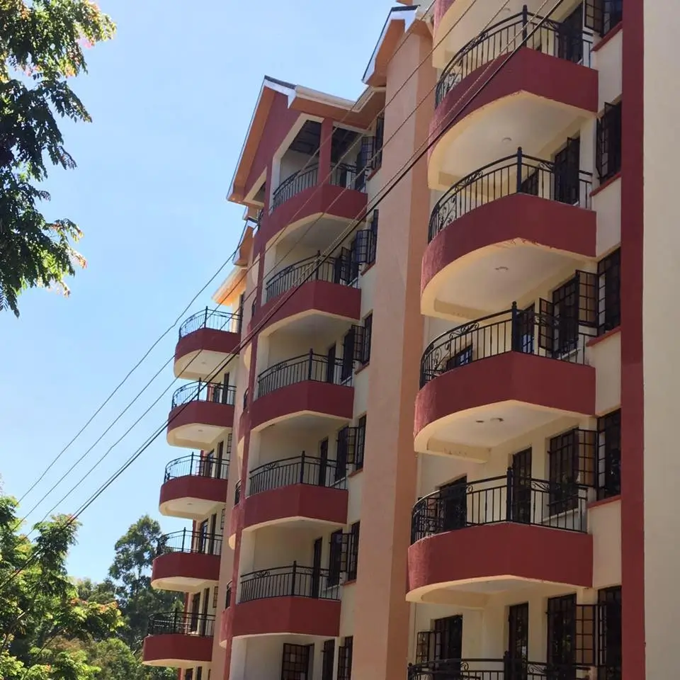 Multi-story residential building with red and cream facade, balconies