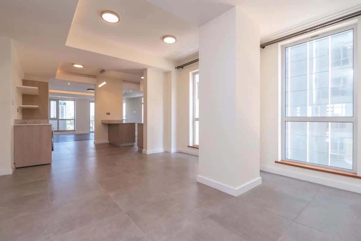 Open-plan living space with kitchen visible in background