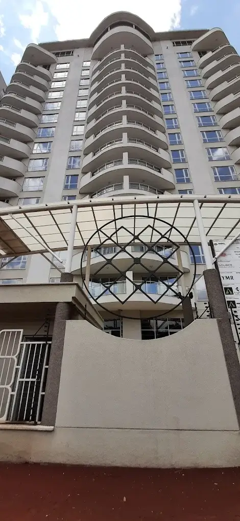 Modern curved residential building facade with balconies and entrance