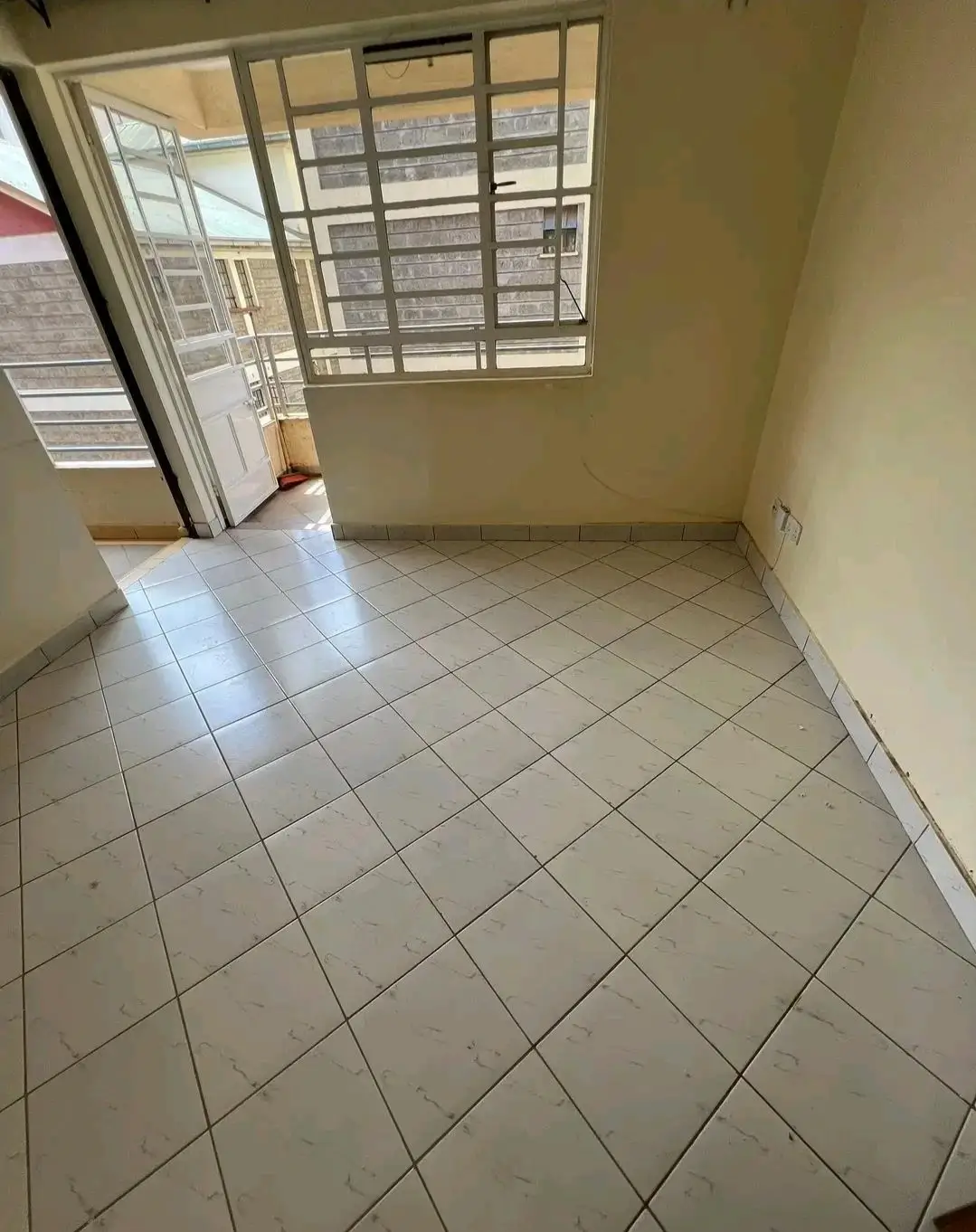 Bright living space with tiled floor and large windows