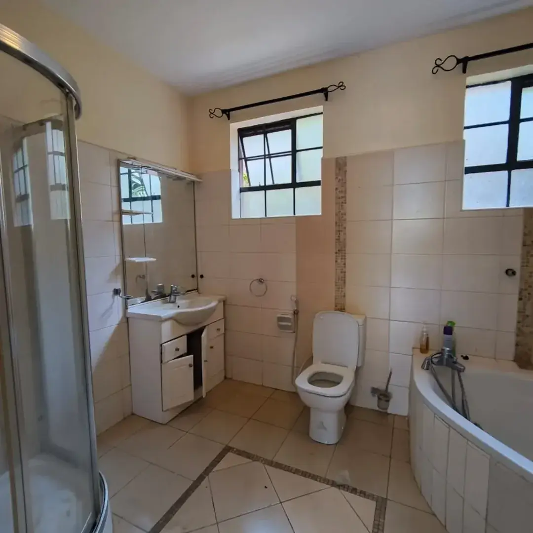 Spacious bathroom with shower, toilet, bathtub, and dual windows