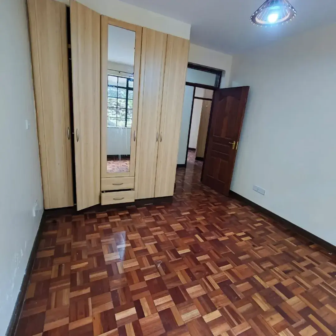 Spacious bedroom with wooden wardrobe and parquet flooring