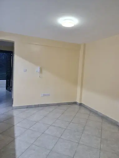 Empty living room with cream walls and tiled flooring