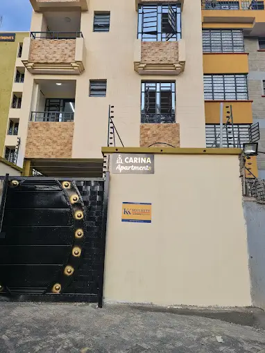 Multi-story apartment building facade with black gate entrance
