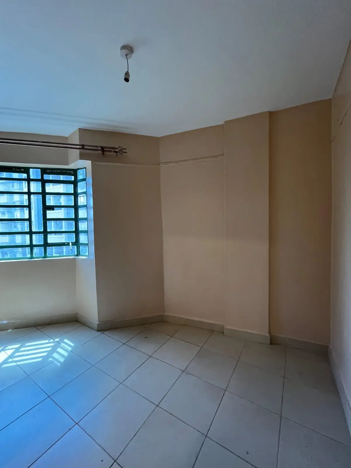 Unfurnished bedroom with tiled floor and natural light
