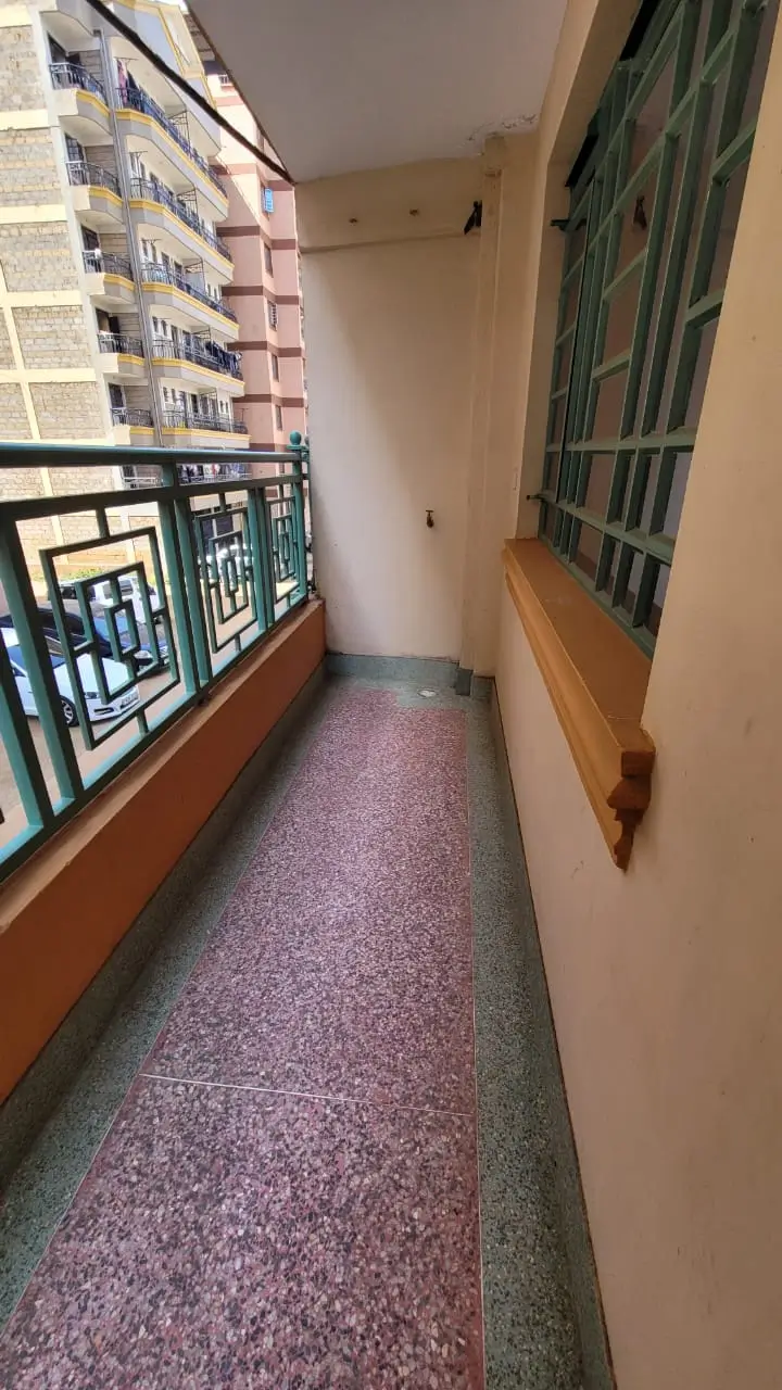 Narrow balcony with city building views and window frames