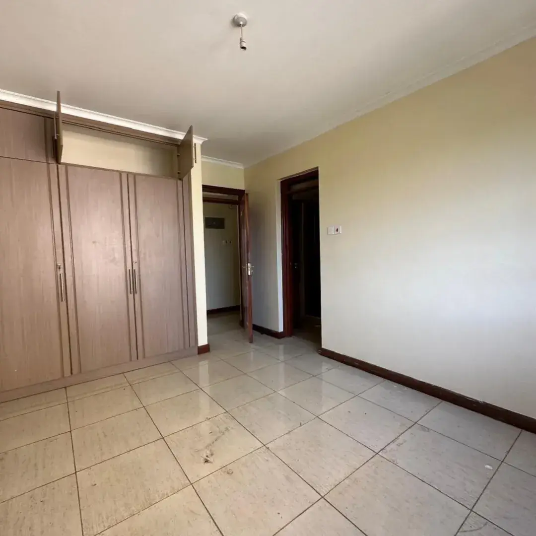 Spacious bedroom with built-in wardrobes and tiled flooring