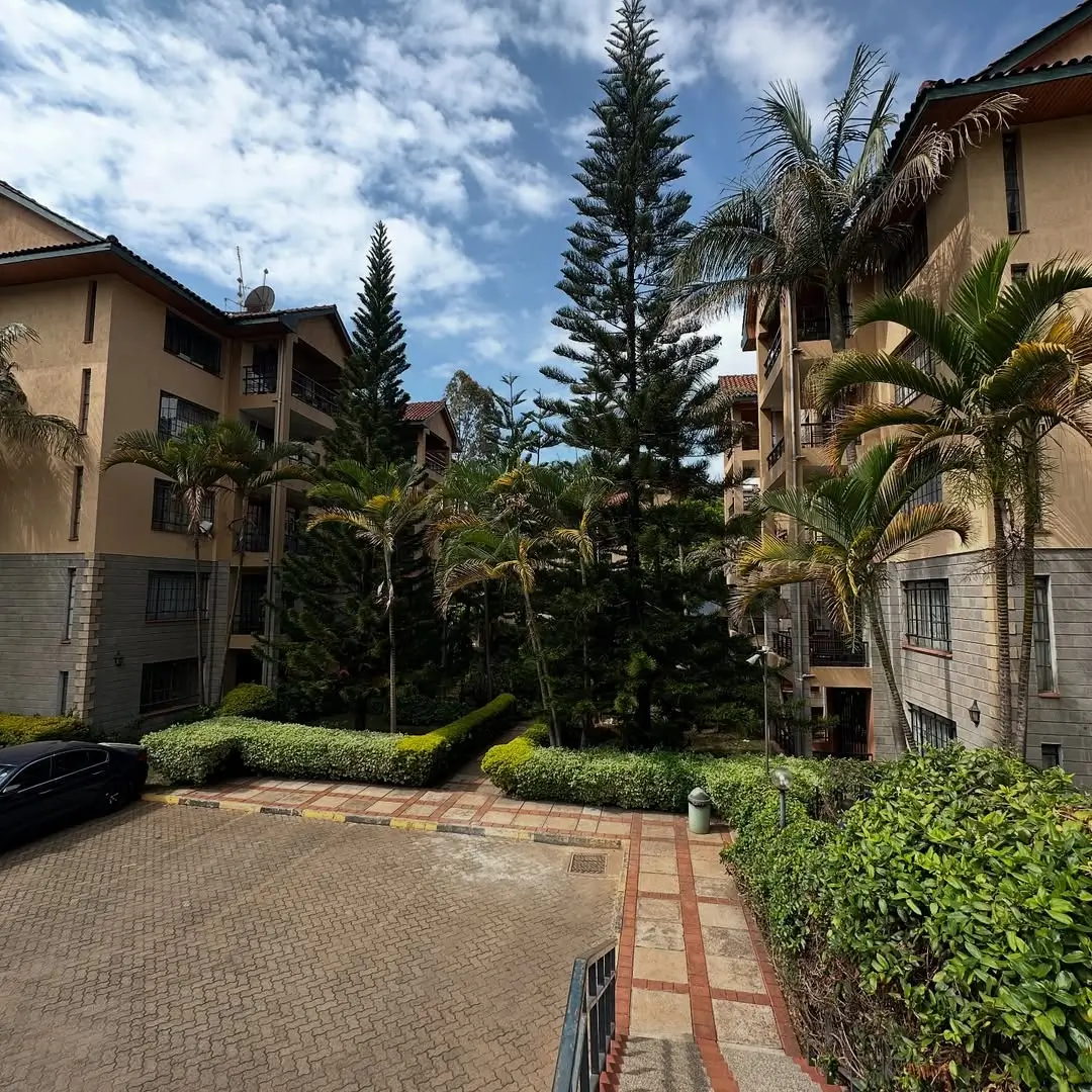 Residential compound with manicured gardens and brick driveway