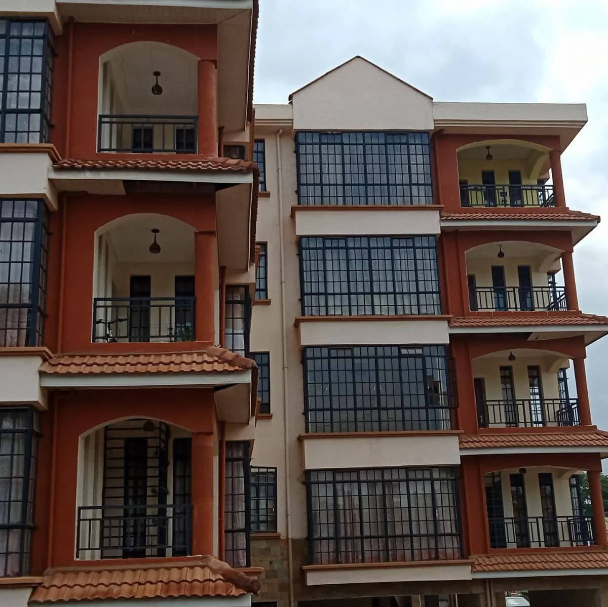 Multi-story residential building with red facade and balconies