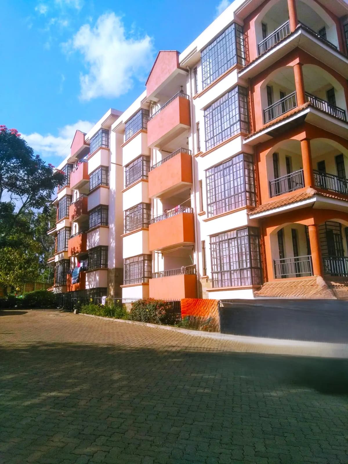 Modern multi-story residential building with orange and white facade