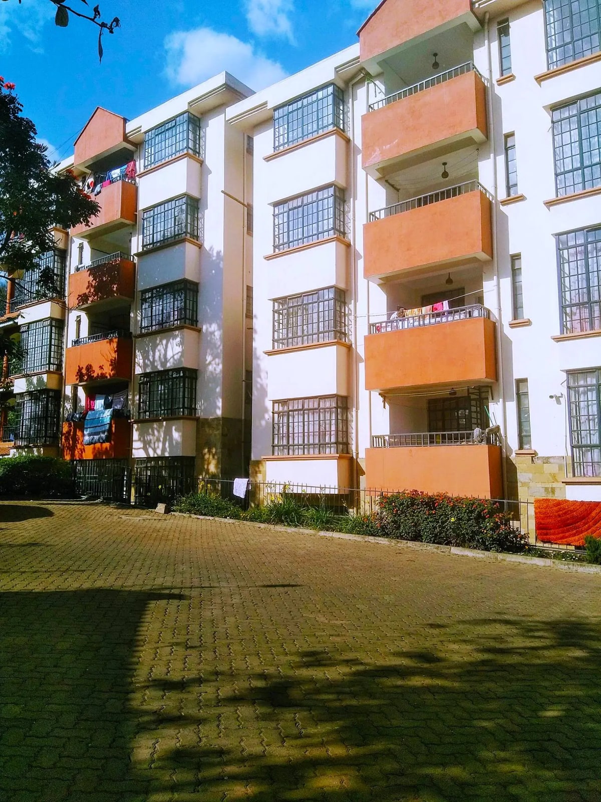 Modern apartment building with orange balconies and manicured grounds