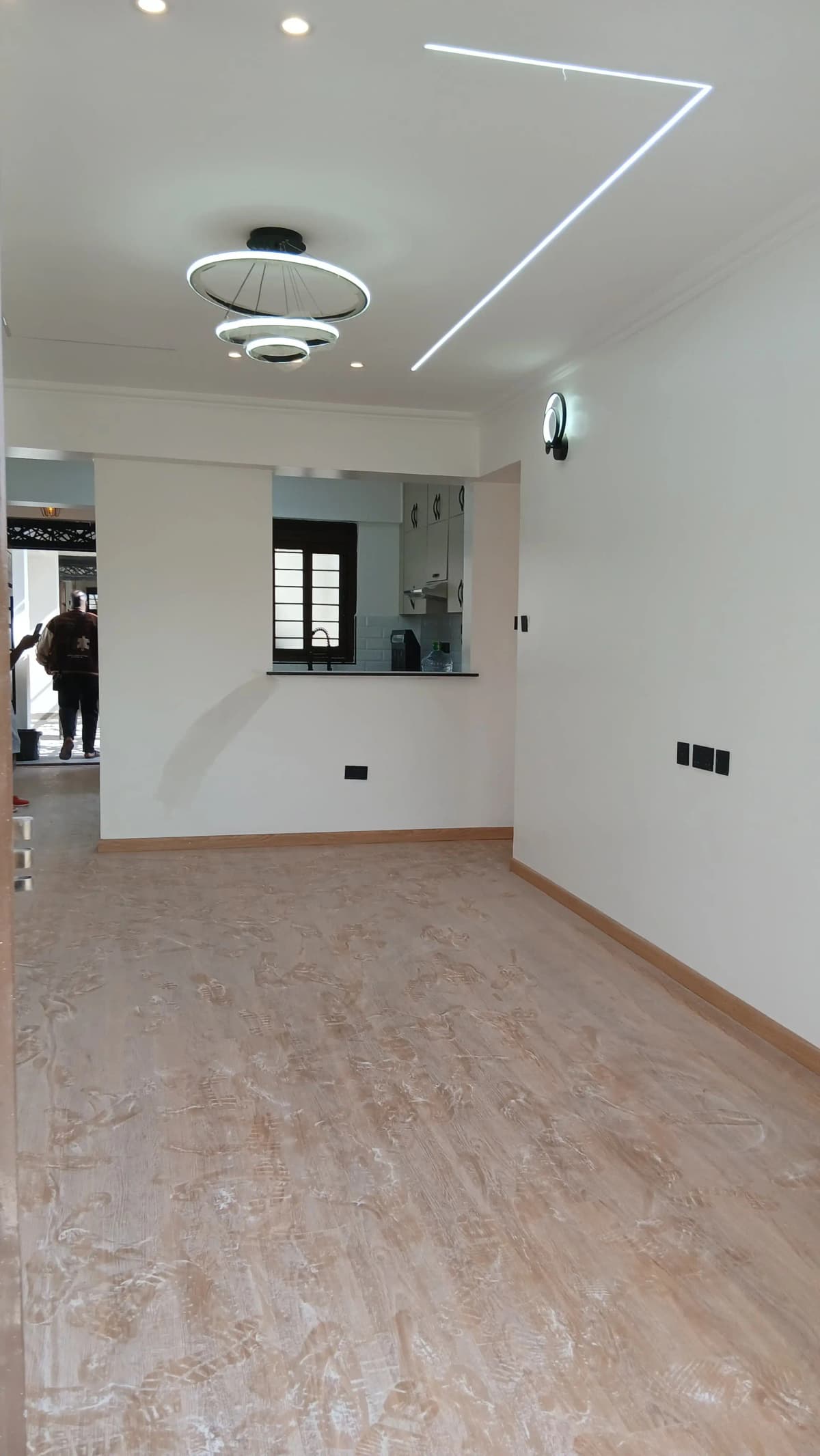 Modern living room with open-plan kitchen pass-through, wood flooring