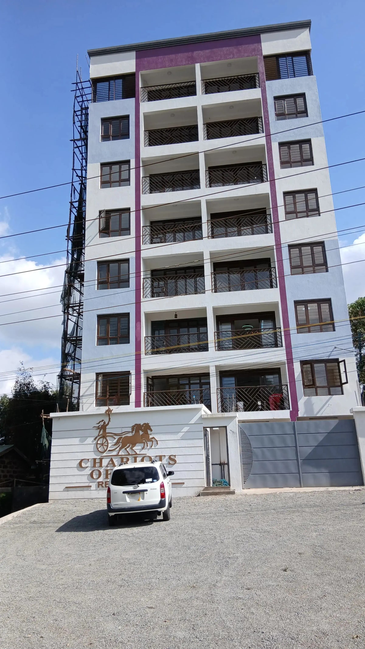 Modern multi-story residential building with ground-level parking bay