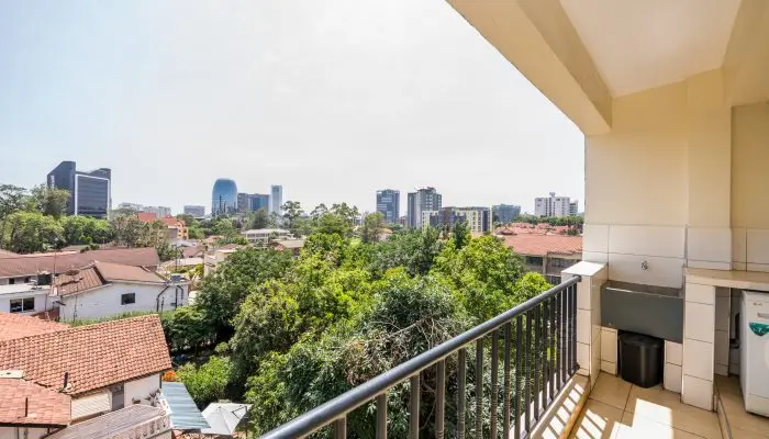 City skyline view from elevated balcony with tree canopy